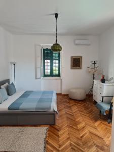 - une chambre avec un lit et du parquet dans l'établissement Nana's Place, à Tivat