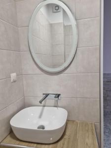 a bathroom with a white sink and a mirror at Anna Christina Apartments in Metamorfosi