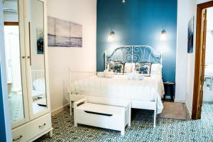 a bedroom with a white bed and a blue wall at Ancha Village in Marbella
