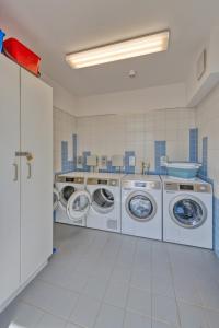 a laundry room with three washing machines in it at StroamCamp Schwedt in Schwedt