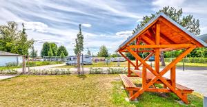 une petite structure en bois avec un banc dans un parc dans l'établissement StroamCamp Schwedt - a84452, à Schwedt-sur-Oder