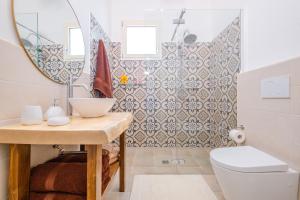 a bathroom with a sink and a toilet and a mirror at Villa Palamita Luxury - Specchia in Specchia