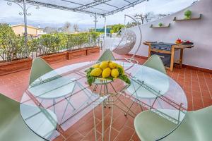 a glass table with a bowl of lemons on a balcony at AMORE RENTALS - Resort Ravenna - Villa Cavaliere in Massa Lubrense