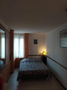 Un dormitorio con una cama y una lámpara. en Maison chaleureuse, en Saint-Jean-dʼAngély
