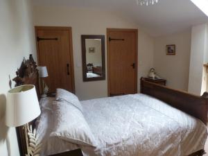 um quarto com uma cama grande e um espelho em Mile House Barn Bed & Breakfast em Nantwich