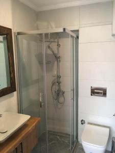 a bathroom with a shower with a toilet and a sink at By Muhtar Hotel Bodrum in Bodrum City