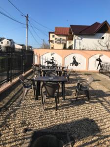 a group of tables and chairs in front of a fence at Vila Flavia in Costinesti +9 photos