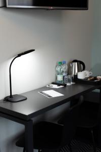 een zwart bureau met een lamp erop bij So Stay Hotel in Gdańsk