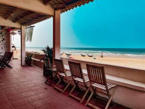 a porch with chairs and a view of the beach at orange house in Tam Kỳ