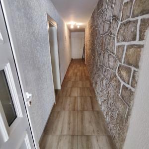 um corredor com uma parede de pedra e um piso de madeira em Real Apartments em Budva