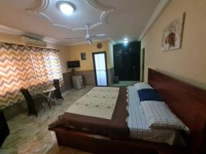 a bedroom with a bed and a desk in a room at NESTA BARRON -Home Away from Home in North Legon