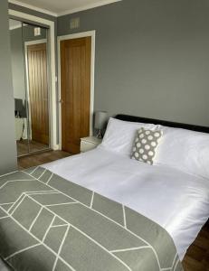a bedroom with a large bed with white sheets at ESNA, Stromness in Stromness