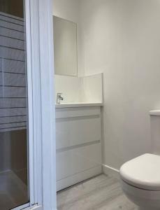 a white bathroom with a toilet and a sink at ESNA, Stromness in Stromness