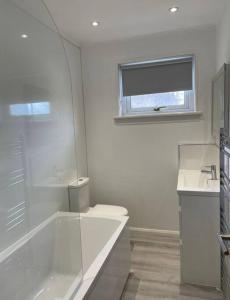 a bathroom with a tub and a toilet and a window at ESNA, Stromness in Stromness