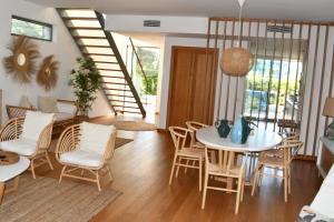 a dining room with a white table and chairs at Villa Mar in Troia