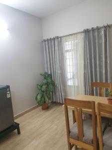 a dining room with a table and chairs and a window at Bergauf Apartment in Pokhara