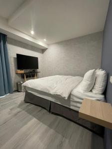 1 dormitorio con 1 cama y TV de pantalla plana en 虎尾小9窩, en Huwei