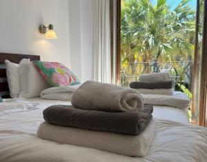 un mucchio di asciugamani seduti sopra un letto di Beachhouse 2min to the sea with pool & wonderful garden a Calvià