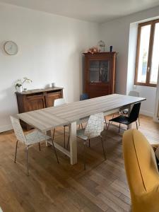 Grande maison conviviale في فونتيناي لو كومت: غرفة طعام مع طاولة وكراسي خشبية كبيرة