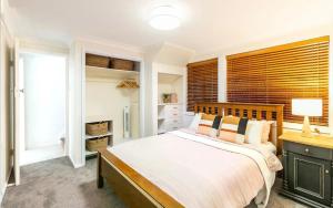 尼尔森湾Port Stephens Home walk to the Beach and Town Centre的带一张大床和一扇窗户的卧室