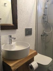 By Muhtar Hotel Bodrum في بودروم: حمام مع حوض ومرحاض ومرآة