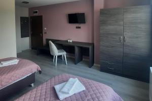 a bedroom with two beds and a desk and a television at Zora in Blagoevgrad