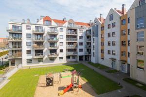 an apartment yard with a playground in front of a building at City Center Apartment with Balcony by Renters in Gdańsk