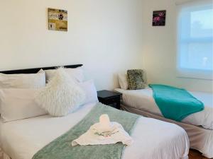 a room with two beds with a hat on them at Palm Heaven B&B in East London