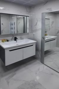 a white bathroom with two sinks and a mirror at Zora in Blagoevgrad