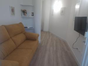 ein Wohnzimmer mit einem Sofa und einem TV in der Unterkunft Vivienda vacacional casa Dora in Valverde