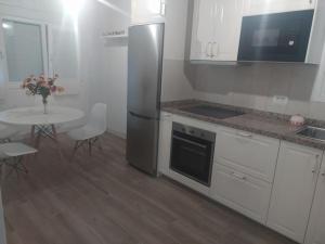 a kitchen with a table and a stainless steel refrigerator at Vivienda vacacional casa Dora in Valverde