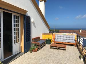 een patio met een bank en een bank op een balkon bij LAVA Açores Coliving & Coworking in Ribeira Grande