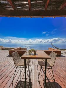 a table and chairs on a deck with a view of the ocean at SECRET HILL in Athani