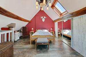 1 dormitorio con cama y pared roja en Tikazanou - Charmante maison pour 4, 