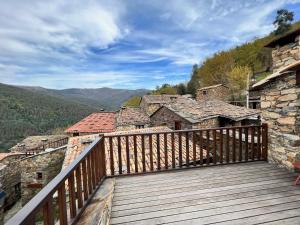 a wooden balcony with a view of a building at Casas do Talasnal in Lousã