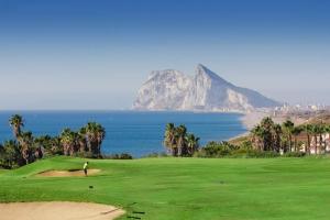 a man on a golf course with a view of the ocean at Apartment Alcaidesa in La Alcaidesa