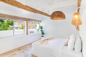 a white bedroom with a bed and a window at Giritimu B'yaz in Selimiye