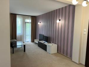 a living room with a flat screen tv and a couch at Chiflika Family Hotel in Asenovgrad