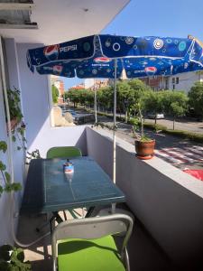 a table and chairs on a balcony with an umbrella at Апартамент Иванови in Pomorie