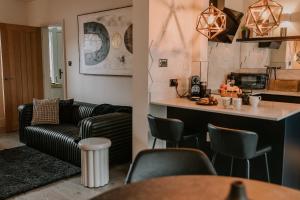 a living room with a couch and a kitchen at 37 Jubilee Street in Llandudno