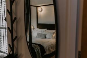 un dormitorio con una cama y un espejo en 37 Jubilee Street, en Llandudno