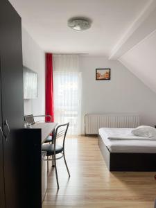 um quarto com uma cama, uma mesa e uma secretária em Pensiunea Aliart em Zărneşti