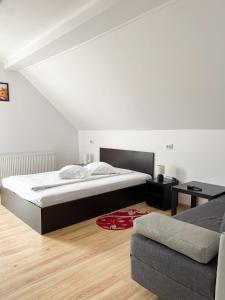 1 dormitorio con 1 cama grande y 1 sofá en Pensiunea Aliart, en Zărneşti