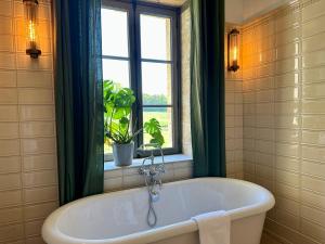 a bath tub in a bathroom with a window at Chateau des Arpentis in Amboise