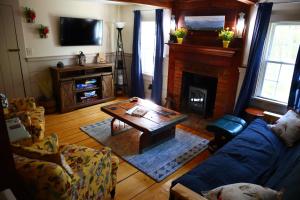 sala de estar con mesa de centro y chimenea en Romantic, Secluded Historic Cottage on 5 Acres 30 mins to TIEC en Landrum