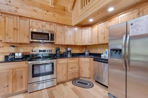 a kitchen with wooden cabinets and stainless steel appliances at Simply Unforgettable in Gatlinburg