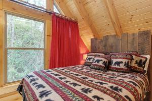 a bedroom with a bed and a window in a log cabin at Simply Unforgettable in Gatlinburg +25 photos