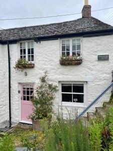 a white house with a pink door and windows at Cosy Cottage Central Marazion with Parking in Marazion