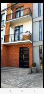 - un bâtiment avec une porte noire et un balcon dans l'établissement Sameba luxury, Golden View, à Tbilissi