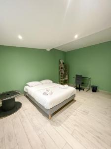 una camera con un letto bianco e una parete verde di L'Eden - Villa cosy à Sainte-Clotilde a Sainte-Clotilde